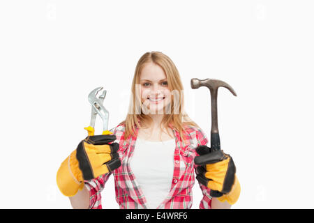 Frau Besitz Werkzeuge während lächelnd Stockfoto