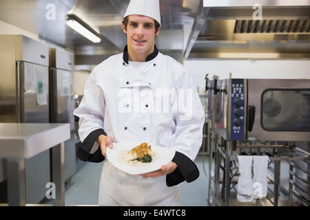 Fröhliche Koch präsentiert seinen Teller Stockfoto