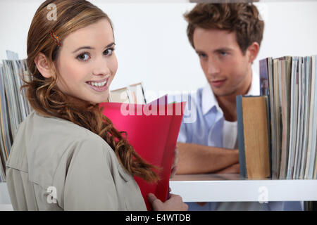 Paar flirten in einer Bibliothek Stockfoto