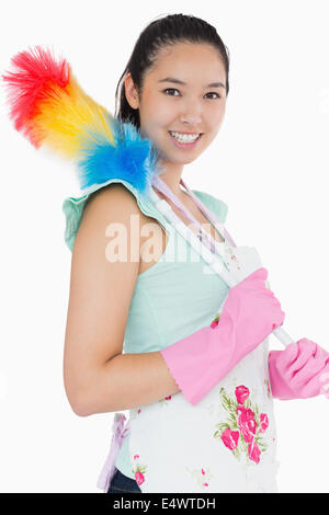 Lächelnde Frau mit Staubwedel Stockfoto