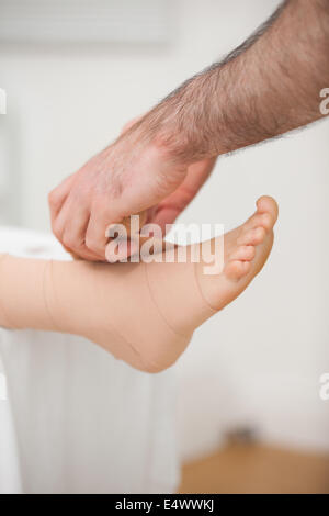 Arzt einen Knöchel Bandagierung Stockfoto