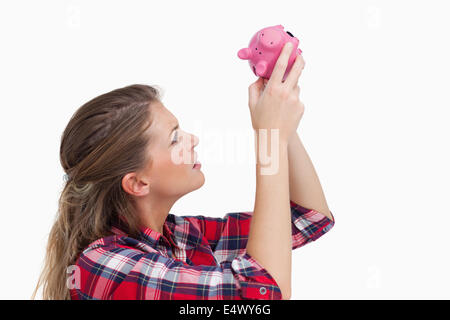 Frau, die im Inneren ein Sparschwein Stockfoto