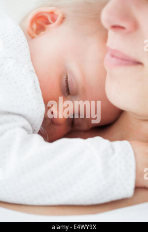 Baby Nickerchen auf der Brust der Mutter Stockfoto