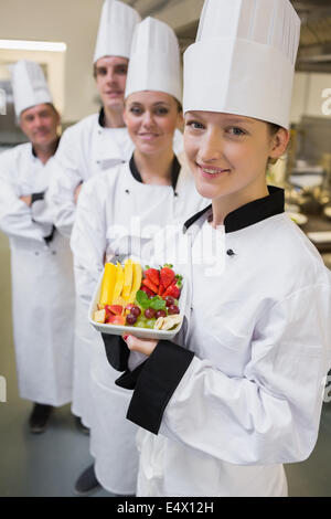 Lächelnd Chef hält Teller mit Obst Stockfoto