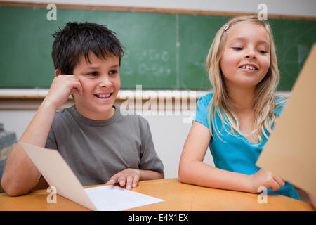 Lächelnde Kinder lesen Stockfoto