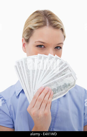 Frau verbirgt ihr Gesicht hinter Geld Stockfoto