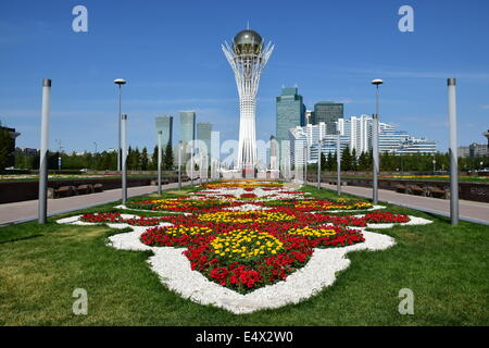 Der BAITEREK-Turm in Astana / Kasachstan mit einigen modernen Türmen und einem schönen Blumenbeet Stockfoto