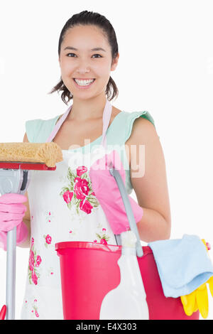 Glückliche Frau hält verschiedene Reinigungswerkzeuge Stockfoto