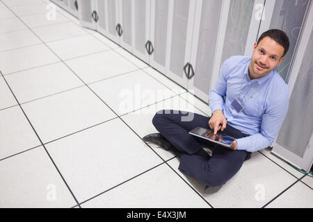 Mann mit Tablet pc sitzen neben Server Stockfoto