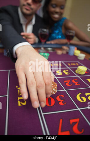 Mann Platzierung Wette beim roulette Stockfoto