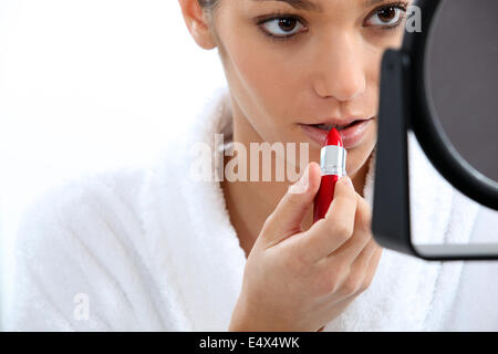 Frau Auftragen von Lippenstift vor Spiegel Stockfoto