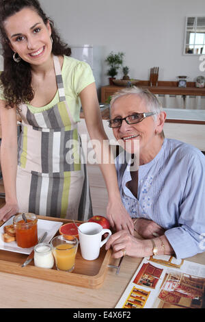 Ältere Frau serviert Frühstück zu Hause Stockfoto