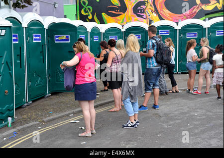 Menschen warten auf tragbare Toiletten am Straßenfest, UK Stockfoto