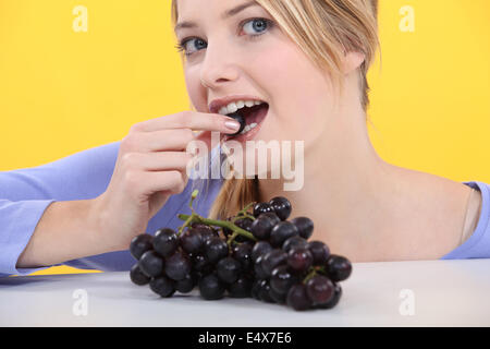 Frau essen Trauben Stockfoto