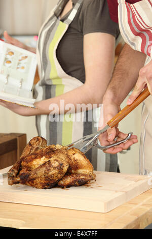 Mann schneiden Huhn auf ein Schneidebrett Stockfoto