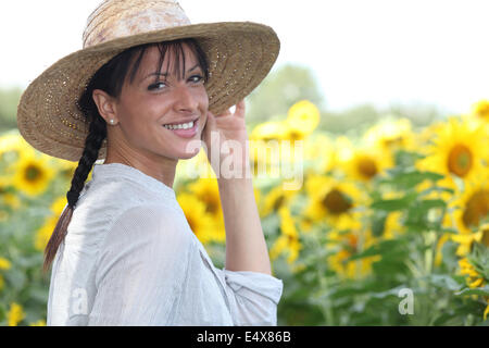 Junge Frau in einem Sonnenblumenfeld Stockfoto
