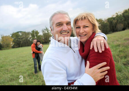 Paare, die in einem Feld umarmt Stockfoto