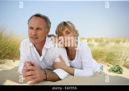 Paar in einer Sanddüne liegend Stockfoto