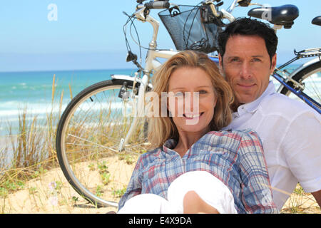 paar am Strand mit Fahrrädern Stockfoto