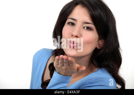 Brünette bläst Kuss an der Kamera Stockfoto