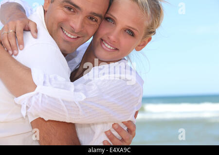 Paar am Strand umarmen Stockfoto