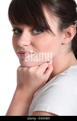 Junge Frau, die ihre Hand am Kinn ruht Stockfoto