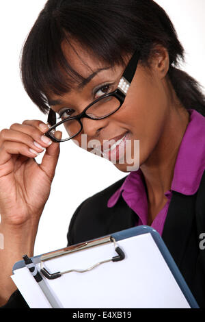 Geschäftsfrau, die über ihre Brille Stockfoto