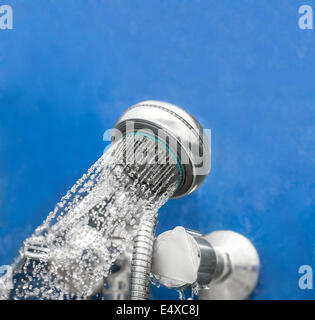 Duschkopf in der Badewanne auf blau Stockfoto