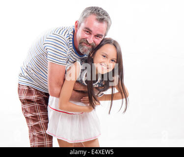 Kaukasische Vater hält Mischlinge, Tochter, glücklich und lächelnd Stockfoto