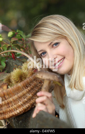 Frau Kastanien sammeln Stockfoto