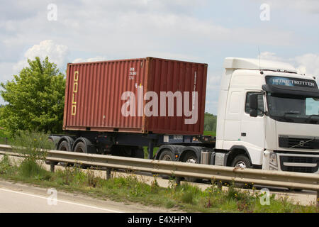 Ein Volvo Globetrotter Lkw schleppen einen Gold-Versandbehälter entlang der A12 Schnellstraße in Essex, England Stockfoto