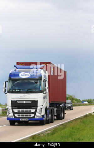 Ein Volvo Lkw schleppen ein Frachtcontainer entlang der A12 Schnellstraße in Essex, England Stockfoto