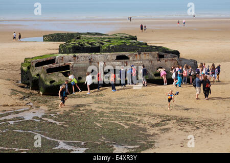 Besucher erkunden die Reste der Mulberry Hafen am Strand von Arromanches Normandie Frankreich im Juli Stockfoto