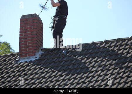 Schornsteinfeger bei der Arbeit auf dem Dach Stockfoto