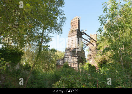 Surrey county Äquivalent von einem Tin Mine verfallenen Kalk Werke Turm versteckt durch die Bäume sich gegen Skyline Stockfoto