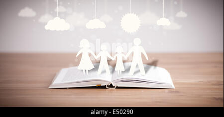 Pappfiguren der Familie auf geöffneten Buch Stockfoto