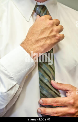 Mann, die Festsetzung einer Krawatte mit Händen Stockfoto