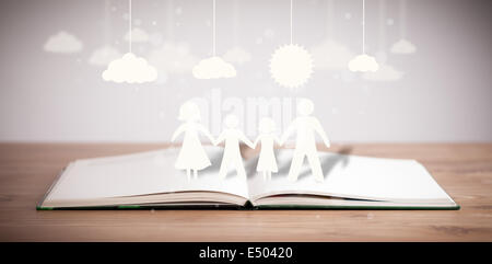 Pappfiguren der Familie auf geöffneten Buch Stockfoto