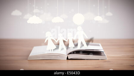 Pappfiguren der Familie auf geöffneten Buch Stockfoto