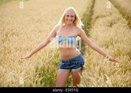 junge schlanke Frau im Maisfeld Stockfoto