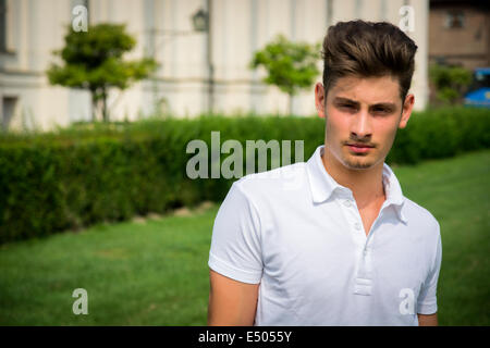 Hübscher junger Mann im Freien, alten eleganten königlichen Palast hinter ihm (Stupinigi Palast in Turin, Italien) Stockfoto