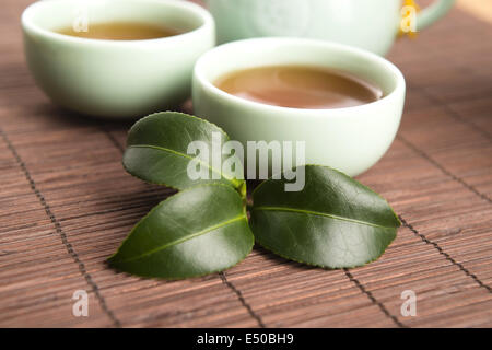 Eine Tasse grüner Tee mit mittelgewichtig Blätter Stockfoto