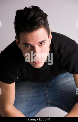 Hübscher junger Mann sitzend, gesehen von oben, Blick in die Kamera Stockfoto