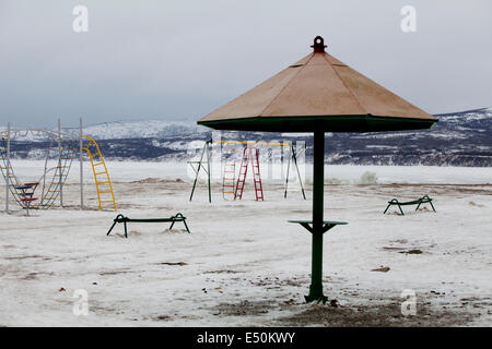 Verschneite verlassenen Spielplatz Klettern Frame Sonnenschirm Stockfoto