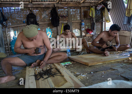 Bali, Indonesien.  Holzschnitzer schnitzen Designs in Fenstern und Türen in Werkstatt. Stockfoto