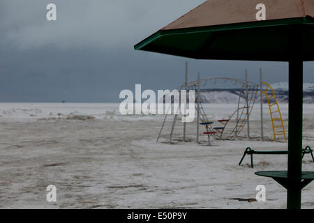 Verschneite verlassenen Spielplatz Klettern Frame Sonnenschirm Stockfoto