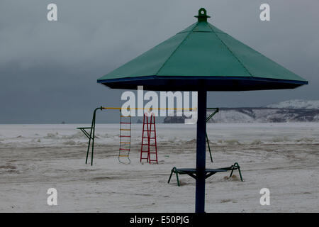 Verschneite verlassenen Spielplatz Klettern Frame Sonnenschirm Stockfoto