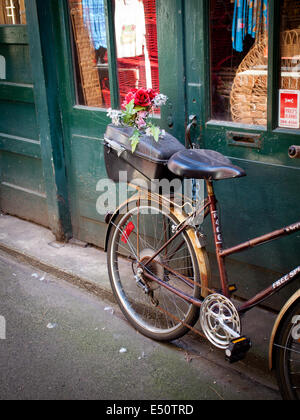 Ein City-Bike mit Blumen in den Rücken geparkt in Fan Tan Alley in Victoria, British Columbia, Kanada. Stockfoto