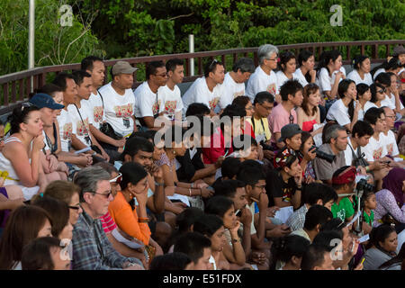 Bali, Indonesien.  Touristen, die gerade den Kecak-Tanz in der Arena neben Uluwatu Tempel. Stockfoto