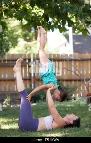 Mutter praktizieren Yoga mit Tochter (6-7) Stockfoto